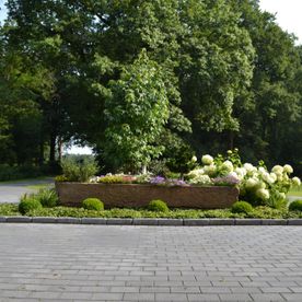 Gepflasterter Weg in einem Garten mit Beet