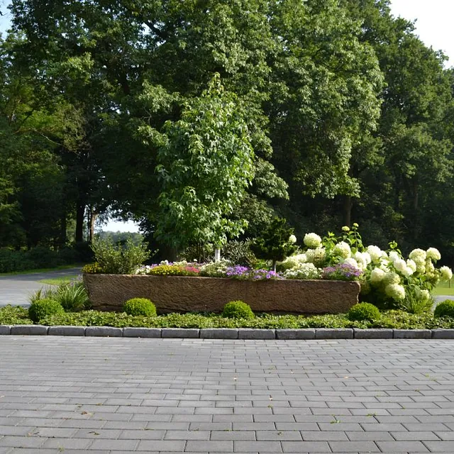 Gepflasterter Weg in einem Garten mit Beet